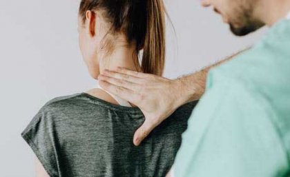 This is an image of a doctor pressing his hand on the back of a woman's neck
