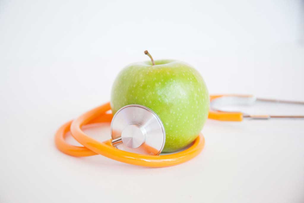 an apple wrapped around a stethoscope