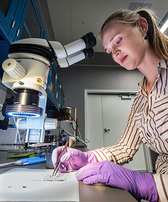 female scientist working over a microscope