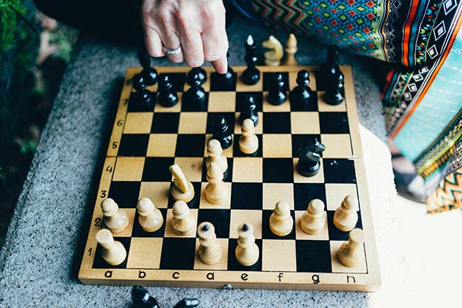 playing chess on an old board with wooden pieces