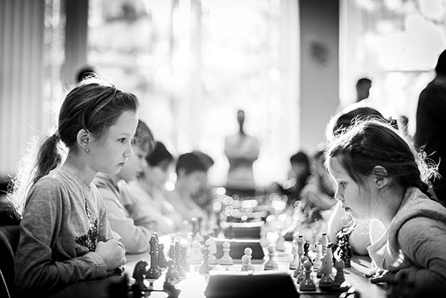 Two young girls playing chess.