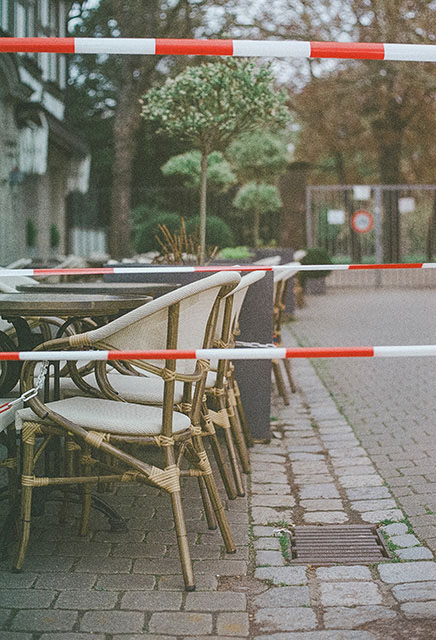 empty outdoor dining separated by caution tape